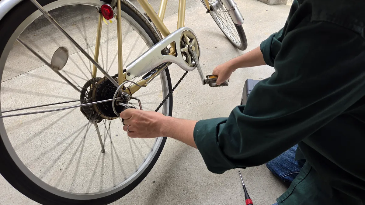 住宅街で自転車の後輪を修理する様子